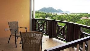 A balcony with wicker chairs and a view of a mountainous landscape. - Beautiful Condo with Fantastic Sea and Sunset Views (Cap Estate)