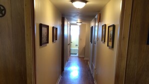A hallway with wooden floors and framed pictures on the walls. - Classic Family Ranch -- Experience Real Texas Country (Montalba)