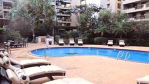 A poolside area with lounge chairs and a swimming pool.