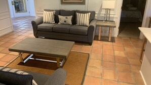 Ein Wohnzimmer mit einer Couch, einem Couchtisch, einem Gemälde und einer Lampe.