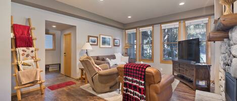 A living room with a fireplace, a sofa, a recliner, and a television.