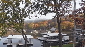 Une zone de quais au bord du lac, avec plusieurs quais et des structures abritées, entourée d’arbres et de bâtiments en arrière-plan.