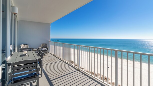 A balcony with a view of the ocean, a white railing, and outdoor furniture. - Newly Updated Direct Gulf View 1BR & Bunkroom/2Bath (Gulf Shores)