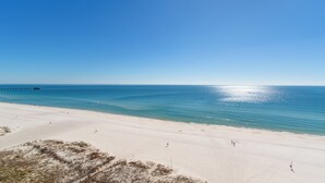 A wide sandy beach with a clear blue sky and calm sea. - Newly Updated Direct Gulf View 1BR & Bunkroom/2Bath (Gulf Shores)