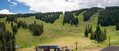 Ein Skigebiet auf dem Berggipfel mit einer Liftstation, Sesselliften und einem Gebäude mit der Aufschrift 'Mountain Top Express'.