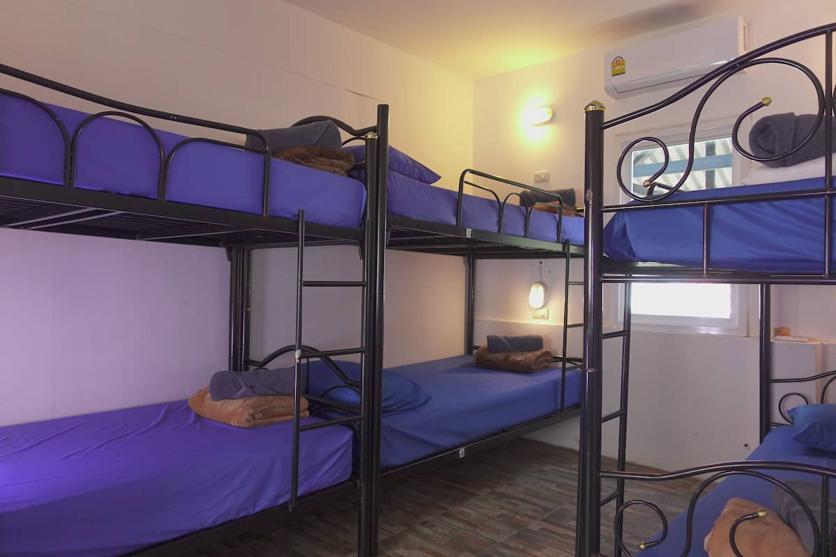 A bunk bed room with two beds, each with blue bedding and pillows.
