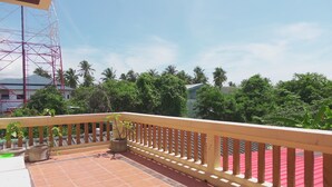 A balcony with a tiled floor, a wooden railing, and potted plants. - Blessing Backpackers (Ko Pha-ngan)