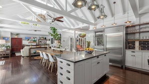 A spacious kitchen with a large island, white cabinetry, and stainless steel appliances. - Blu on White- 4BR Old Town Key West Home with Heated Pool (Key West)