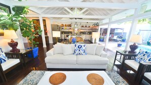 A spacious living area with a white sofa, a coffee table with two woven placemats, and a large plant. - Blu on White- 4BR Old Town Key West Home with Heated Pool (Key West)