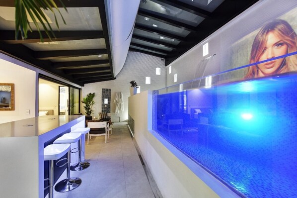 A modern interior with a bar area, seating, and a large aquarium.