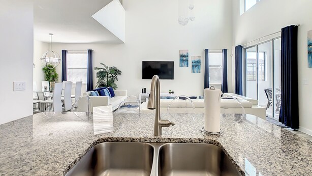 A modern kitchen with granite countertops and a double sink.