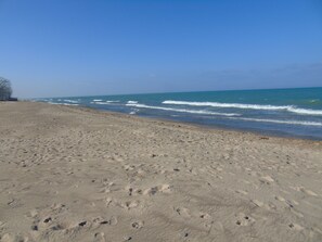 A sandy beach with footprints and waves.