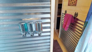 A metal door with four glass containers on the left and a wooden door with a towel rack on the right. - W-W: The Barndominium for Large Groups (Monticello)