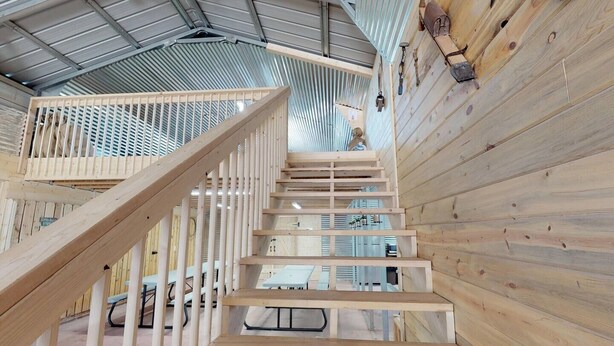 A wooden staircase with a metal railing leading to a higher level. - W-W: The Barndominium for Large Groups (Monticello)