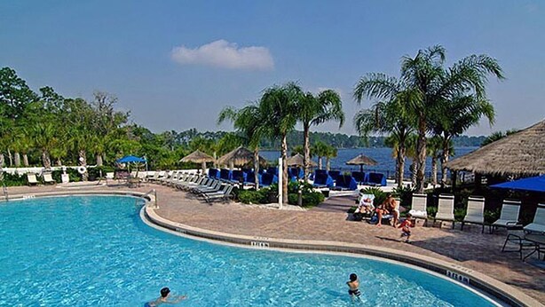 A swimming pool with lounge chairs and palm trees. - Family Friendly Bahama Bay Condo near Disney (Davenport)