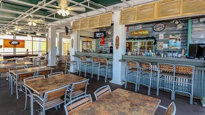 An indoor dining area with tables and chairs, a bar counter, and ceiling fans. - Family Friendly Bahama Bay Condo near Disney (Davenport)