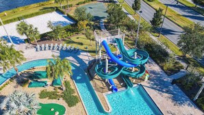Vue aérienne d’un parc aquatique avec de nombreux toboggans, une piscine et un terrain de basketball.