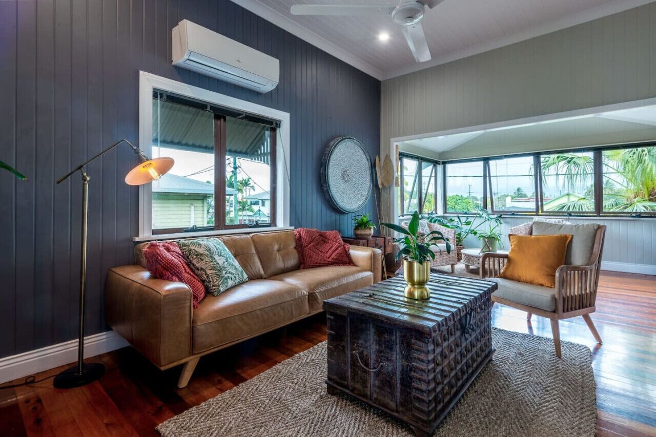 A living room with a leather sofa, a coffee table, a chair, and a large window.