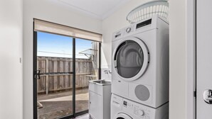 A laundry room with a washing machine, a dryer, and a small cabinet.
