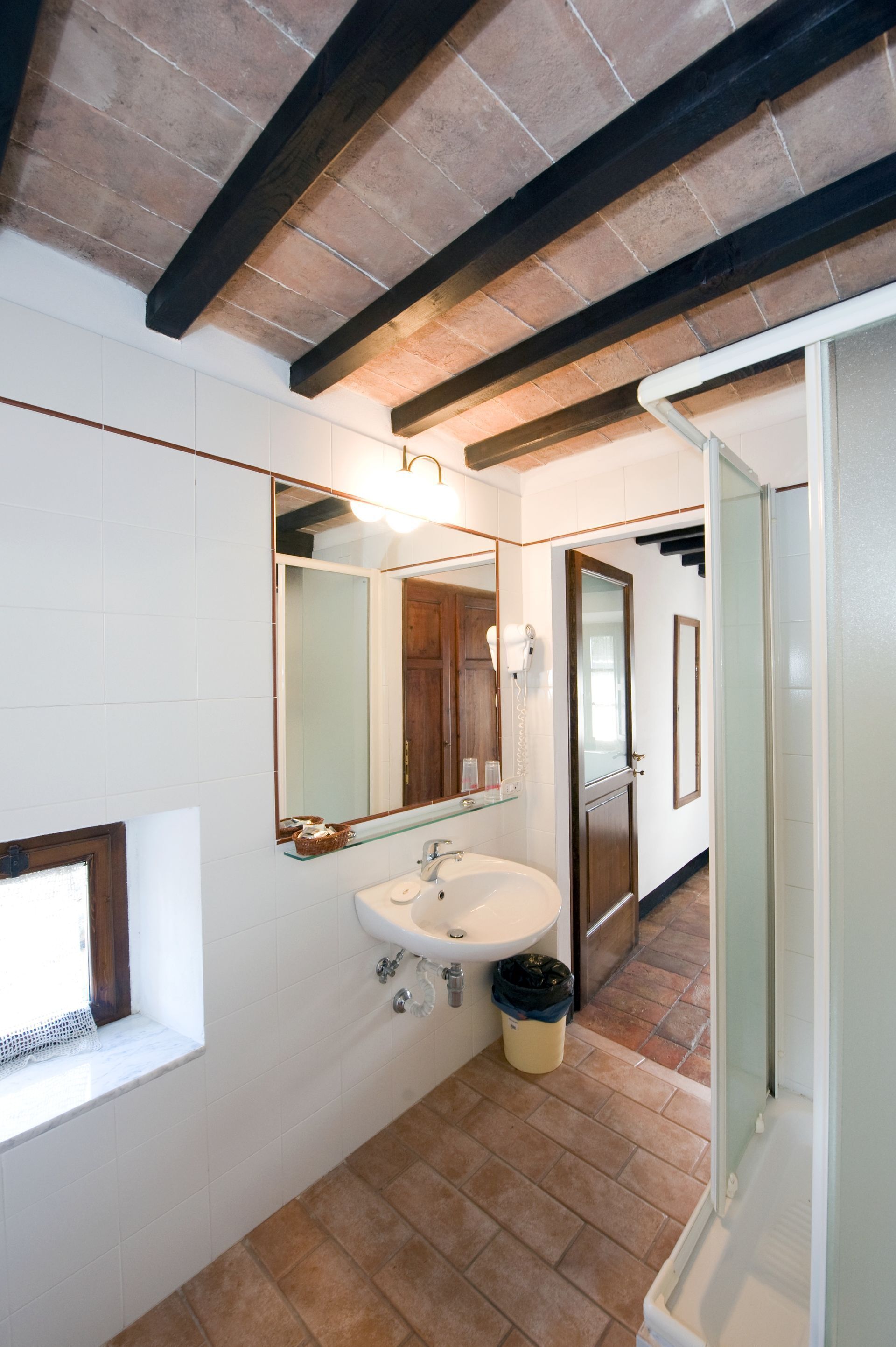 A bathroom with a white sink, a mirror, and a shower.