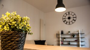 A potted plant on a table with a clock on the wall and shelves in the background. - Ideal starting point to experience Palermo and its many facets! (Palermo)
