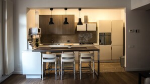 A modern kitchen with a central island, pendant lighting, and built-in appliances. - Ideal starting point to experience Palermo and its many facets! (Palermo)