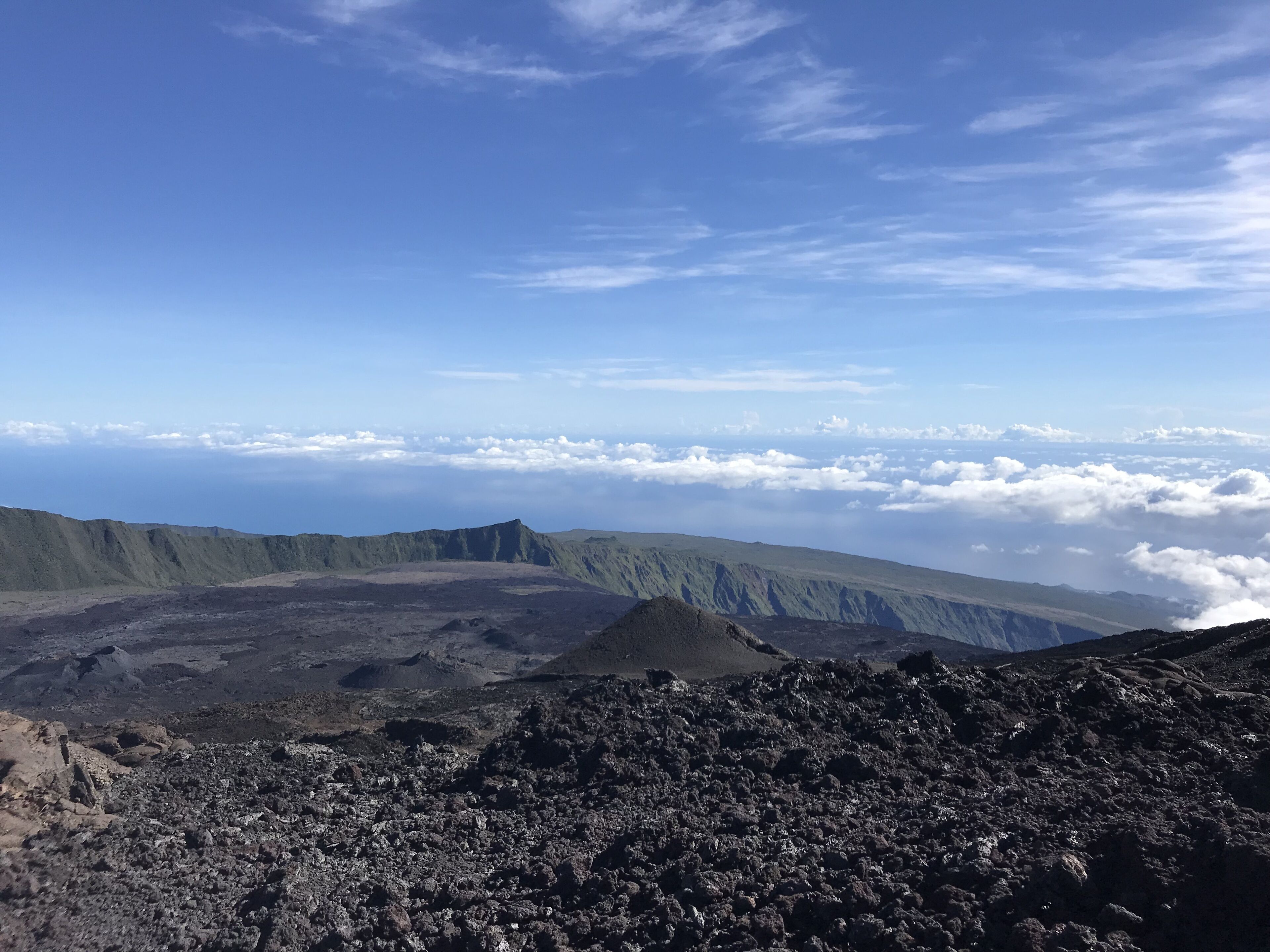 A volcanic landscape with rugged terrain and a clear sky.