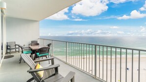 Un balcon avec vue sur l’océan, une table avec des chaises et une balustrade.