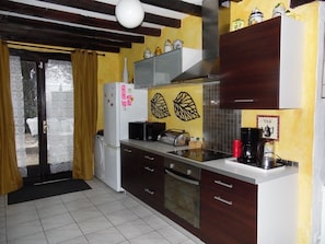 A kitchen with a microwave, toaster, coffee maker, and cabinets.