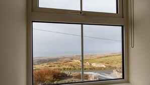 Una habitación con un amplio ventanal que da a un paisaje rural.