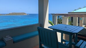 Un balcón con vistas al mar y una isla distante.