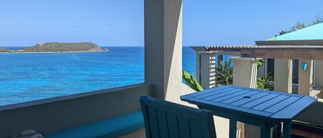 A balcony with a view of the sea and a distant island.