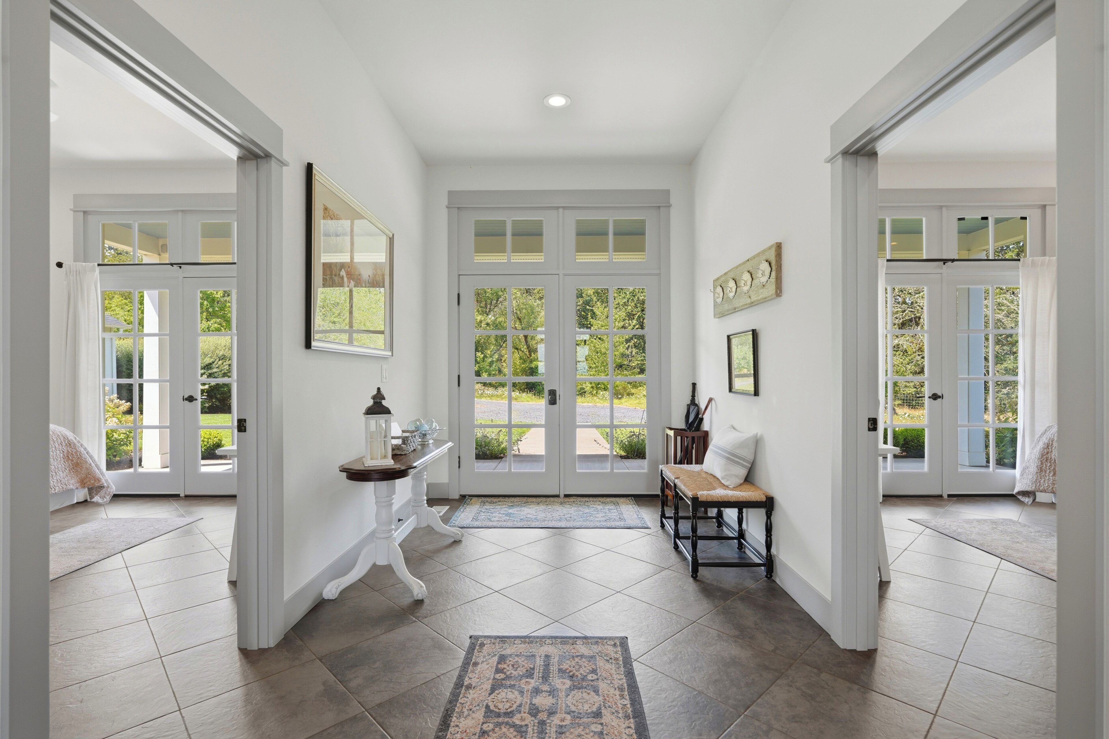A hallway with a bench, a table with a lantern, and a door leading outside.