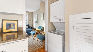 A laundry room with a washing machine, a dryer, and a white door.
