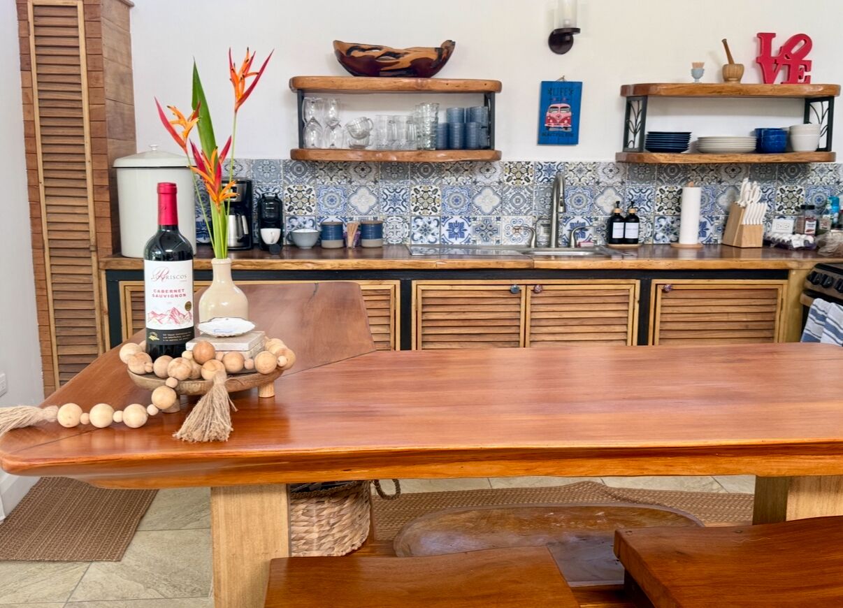 Un tavolo da pranzo in legno con una bottiglia di vino e oggetti decorativi.