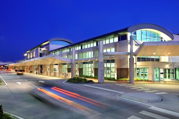 A modern hotel with a curved facade, multiple entry points, and a well-lit entrance.