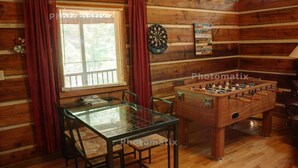 Une pièce chaleureuse équipée d’un baby-foot, d’un jeu de fléchettes et d’un panneau indiquant les règles du jeu.