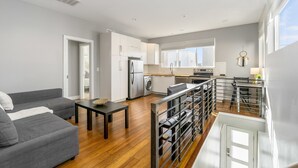 Un appartement moderne comprenant un salon, une cuisine et un balcon.