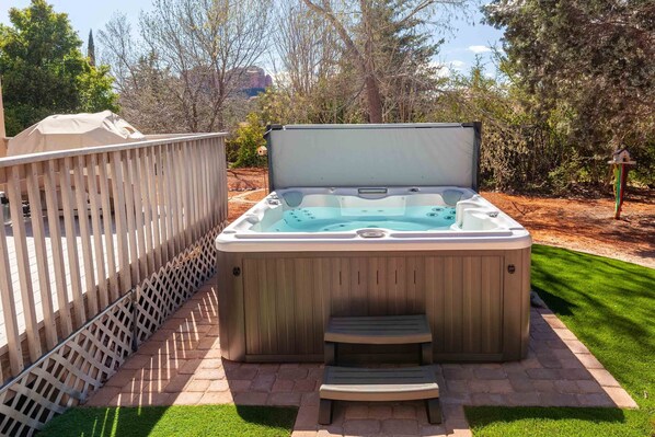 Ein Whirlpool mit Holzverkleidung, einer Leiter und einer Holzterrasse.