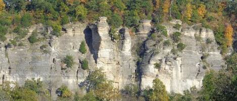 A natural landscape with a prominent rock formation and a road leading towards it.