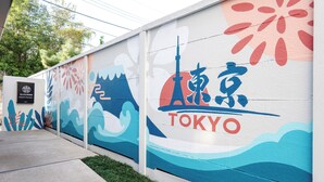 Een muur met Tokyo-thema muurschilderingen, waaronder de Tokyo Tower en golven.