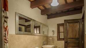 A bathroom with a toilet, sink, and mirror. - Hotel Mansion del Rey (Antigua Guatemala)