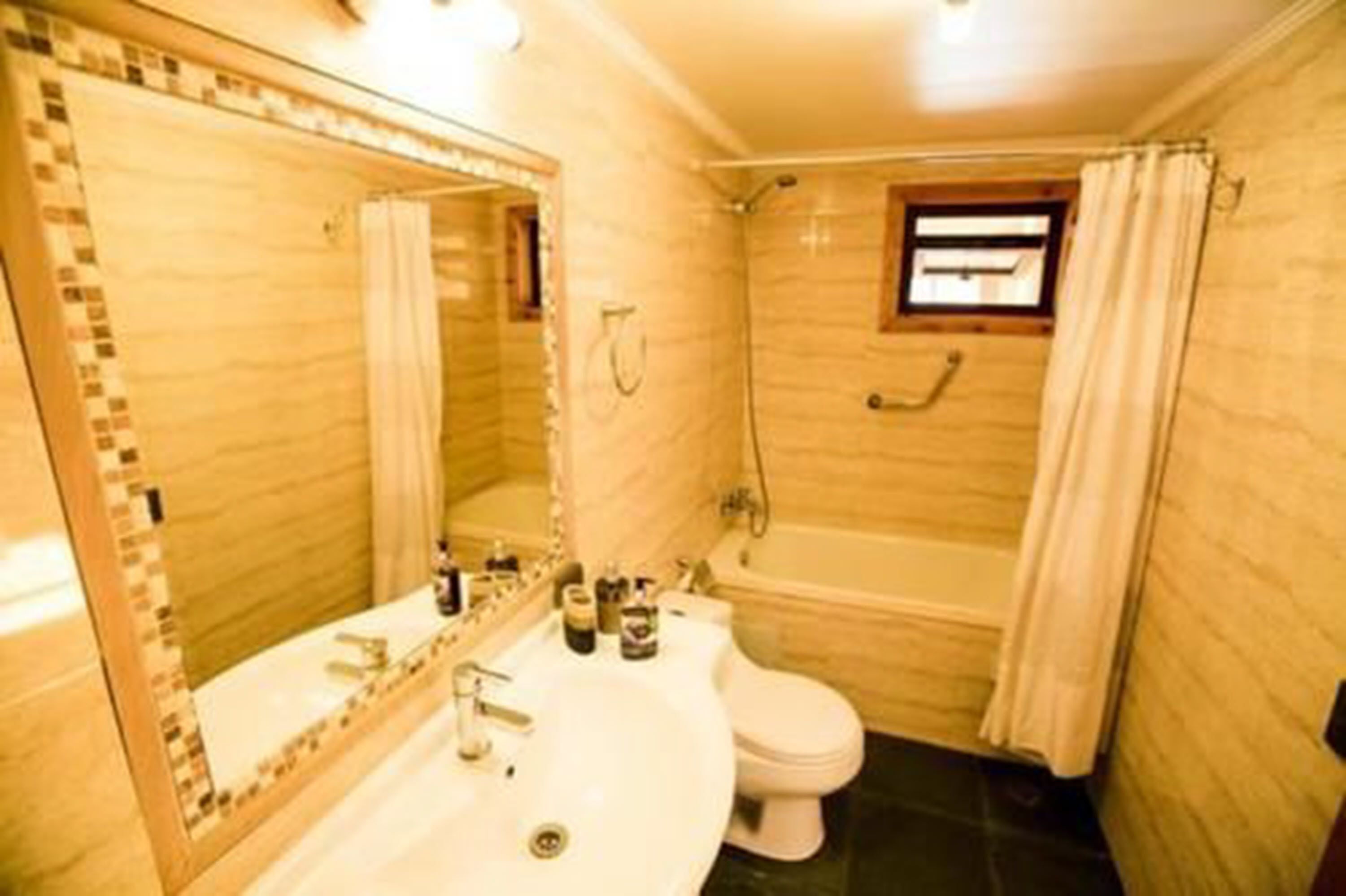 Une salle de bain équipée d’un lavabo, d’un miroir, de toilettes et d’une baignoire.