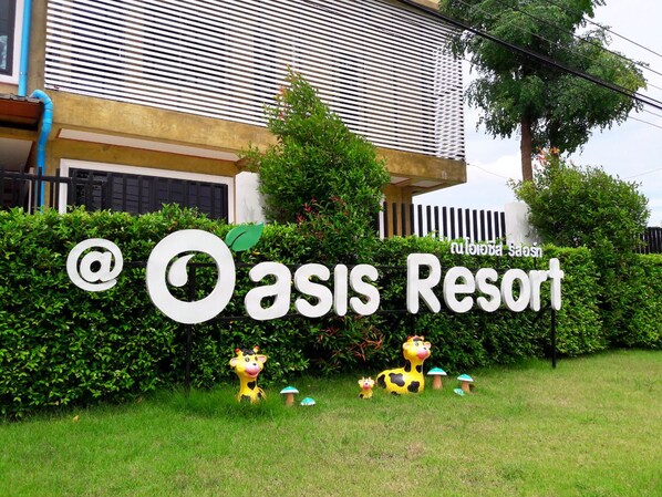 A sign for Oasis Resort with a logo and decorative cow figures. - Oasis Resort (Pranburi)