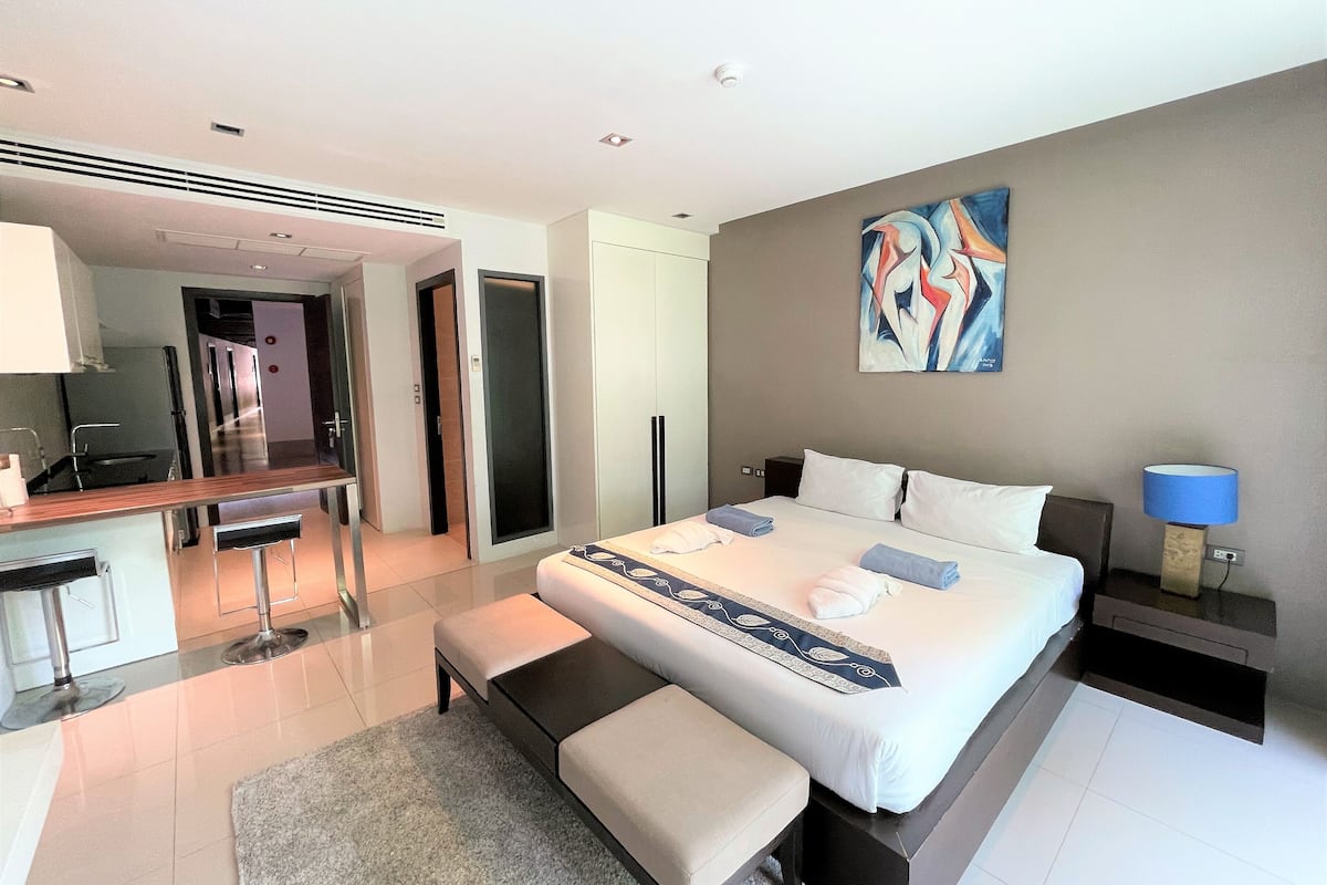 Une chambre d’hôtel moderne avec un grand lit, un bureau et une salle de bain.