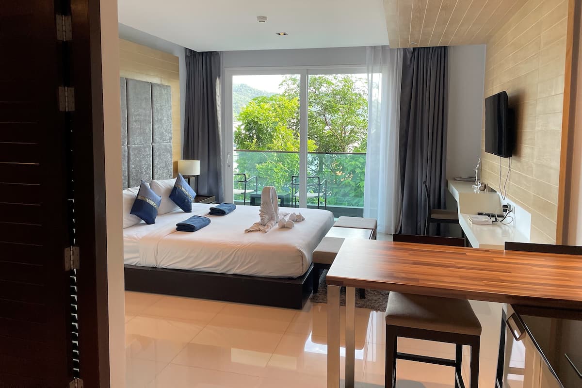 Une chambre d’hôtel moderne, dotée d’un grand lit, d’un bureau et d’une télévision.