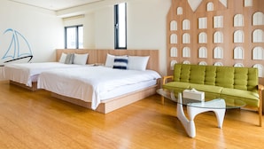A modern hotel room with a large bed, a green sofa, and a glass coffee table. - Chen Feng Homestay (Magong)