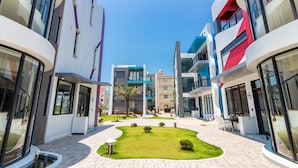 A modern building with a central courtyard, featuring a well-maintained lawn and seating areas. - Chen Feng Homestay (Magong)