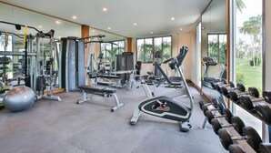 Un gimnasio con diverso equipo de ejercicio, incluyendo cintas de correr, máquinas de pesas y pesas libres.