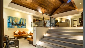 Um interior moderno com escada, sofá e uma pintura.